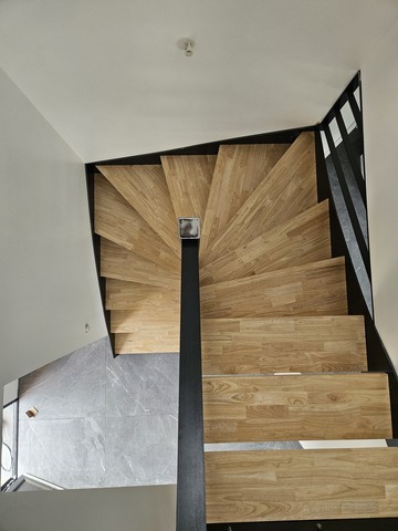 Escalier demi-tournant en acier brut avec marches en hévéa