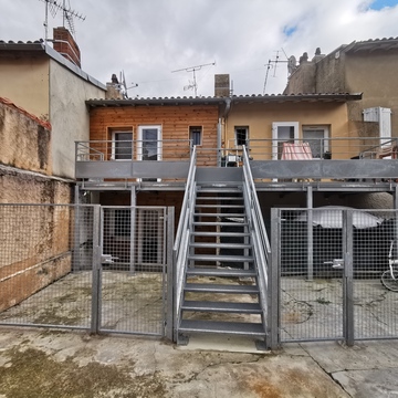 Extension de balcon avec terrasse, garde-corps et plancher caillebotis