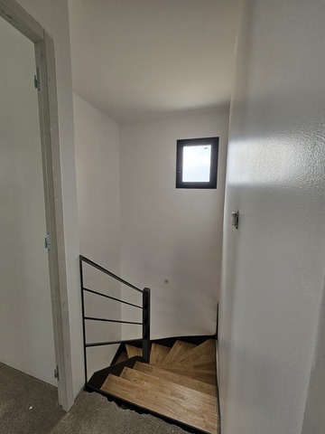 Escalier demi-tournant en acier brut avec marches en hévéa