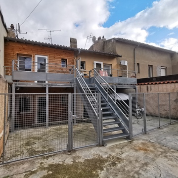 Extension de balcon avec terrasse, garde-corps et plancher caillebotis