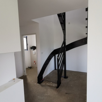Escalier demi-tournant en acier brut avec marches en hévéa